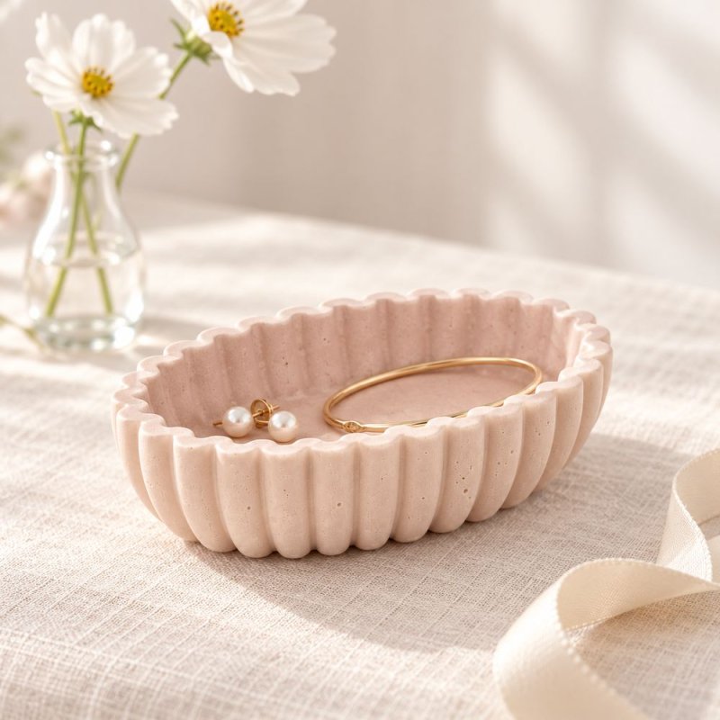 Récipient ovale rose aux parois ondulées utilisé comme porte-bijoux
