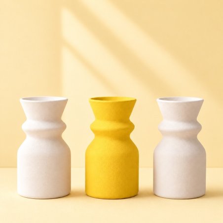 Jarrón amarillo huevo entre dos jarrones blancos, ejemplo de escayola coloreada