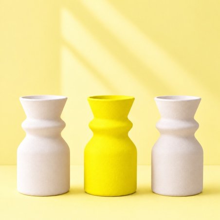Jarrón amarillo limón entre dos jarrones blancos, ejemplo de escayola coloreada