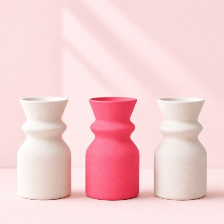 Jarrón rosa chicle entre dos jarrones blancos, ejemplo de escayola coloreada