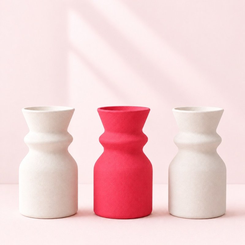 Vase corail entre deux vases blancs, exemple de plâtre coloré