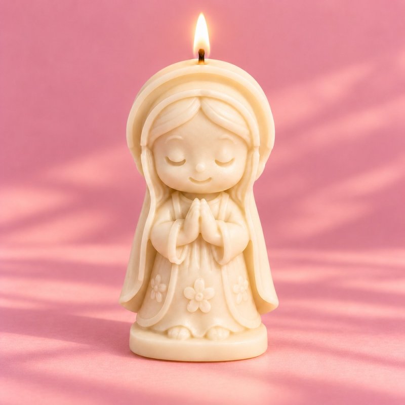 Vela encendida de virgencita rezando en color crema sobre fondo rosa