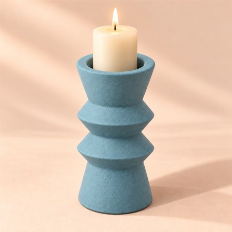 Portavelas geométrico azul de dos anillos con una vela encendida