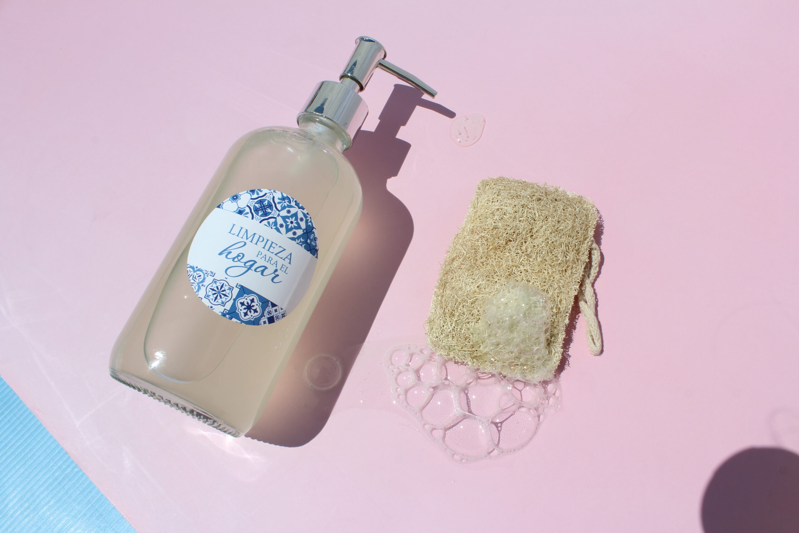 Lavavajillas líquido casero con espuma sobre una esponja vegetal