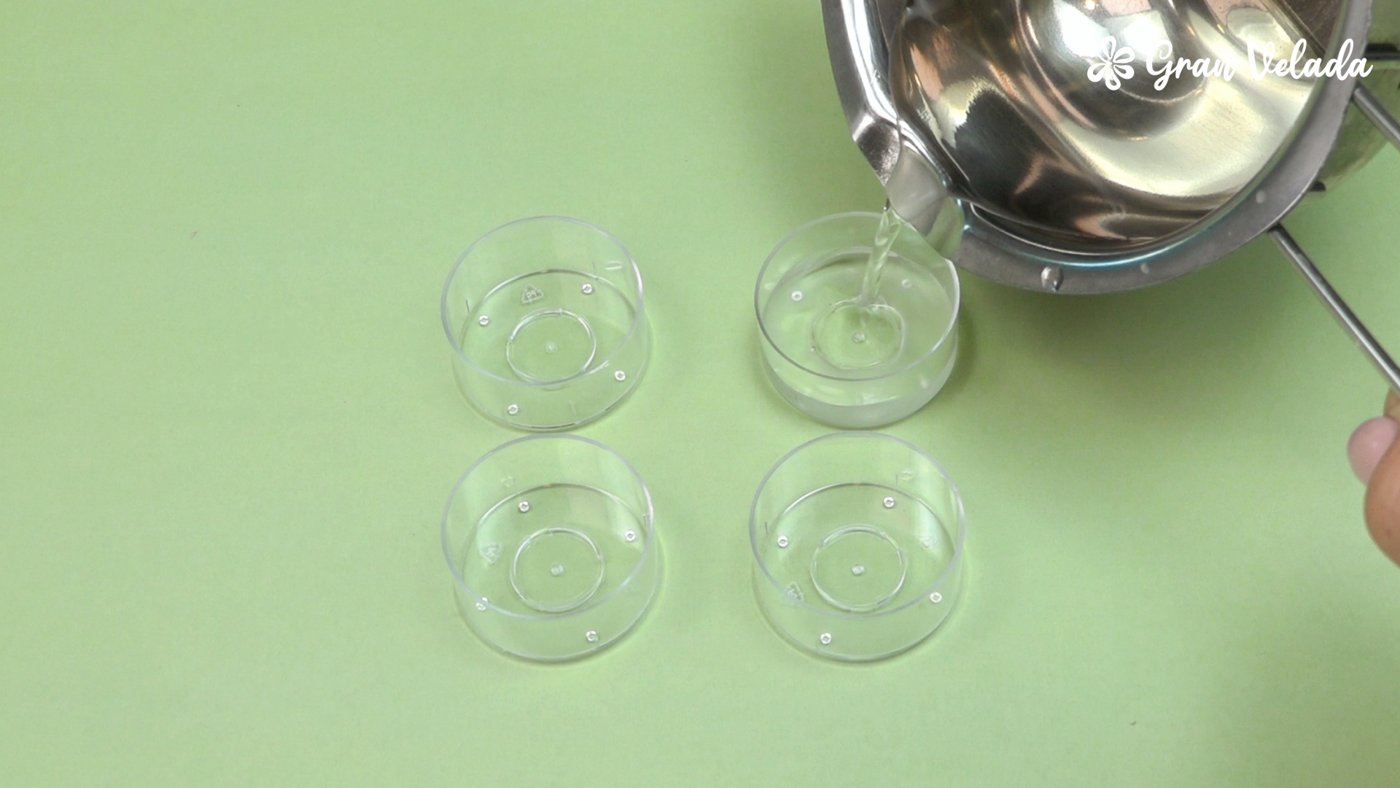 Verter la cera líquida en los cuatro recipientes para velas de té