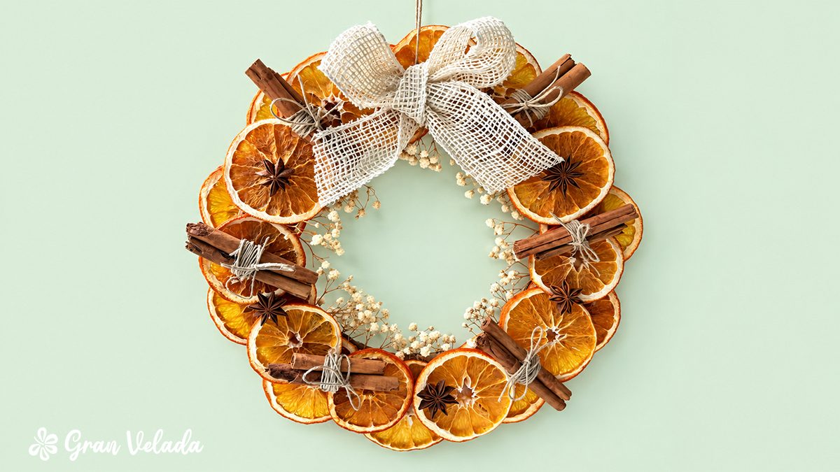 Corona terminada con naranja, canela y lazo blanco