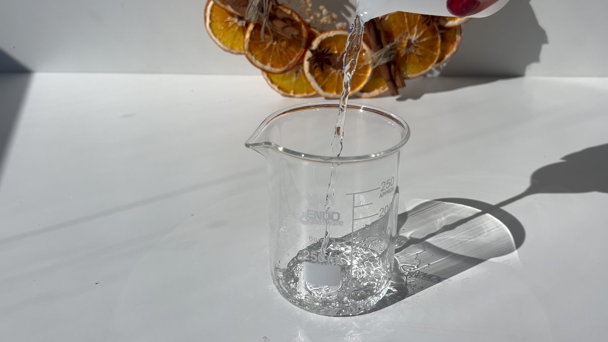 Vertiendo alcohol de perfumería en un vaso medidor para el spray aromático