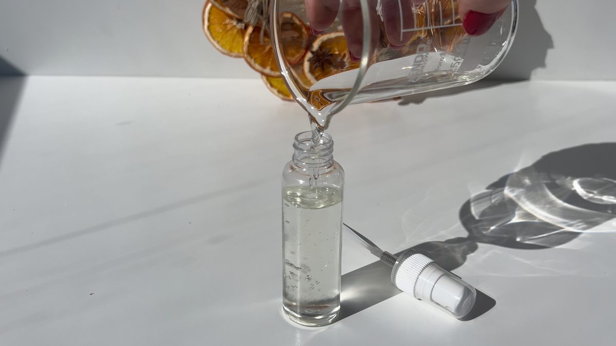 Rellenando una botella con pulverizador con la mezcla de alcohol y esencia