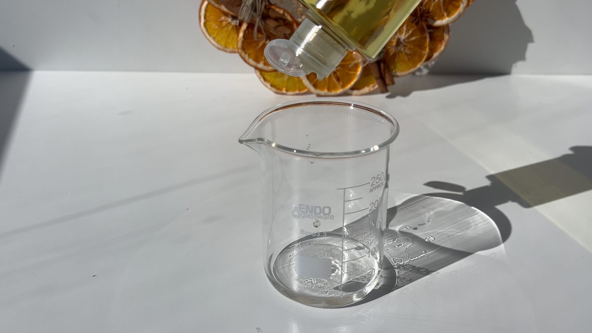 Añadiendo esencia aromática canela naranja al alcohol para preparar el spray