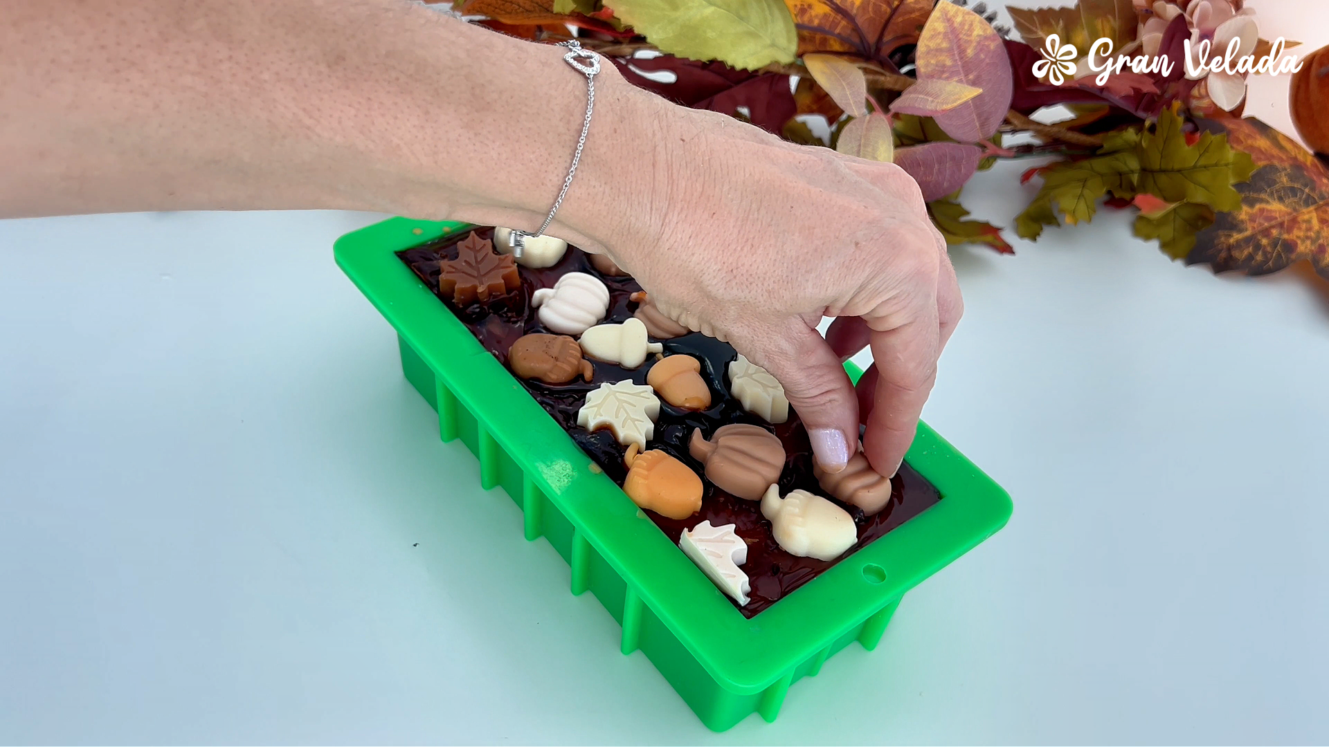 Colocando las pequeñas figuras de otoño sobre la cobertura